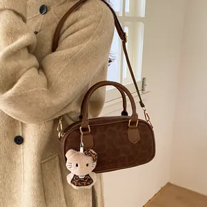 Detail of faux leather leopard print handbag with plush kitty pendant and gold hardware