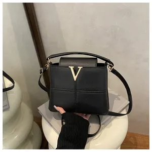 Detail of lychee pattern leather bucket bag with gold V-shape metal hardware