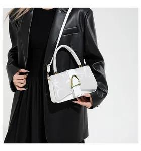 Détail du sac à main en cuir blanc avec motif monogramme et boucle dorée géométrique