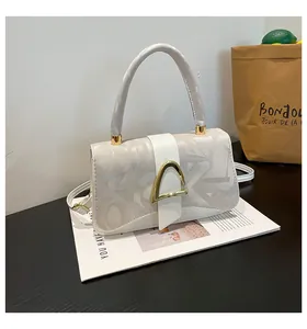 Détail du sac à main blanc cassé avec boucle dorée en D et imprimé abstrait