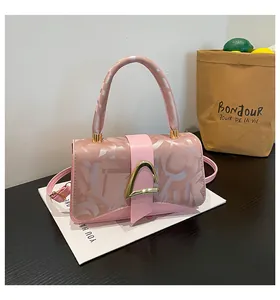 Détail du fermoir fer à cheval doré et texture de lettres sur le sac à main rose