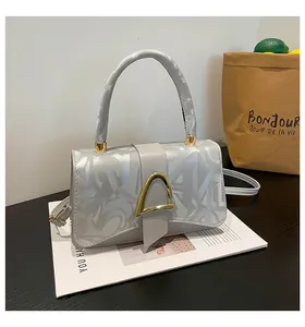 Détail du sac bandoulière gris argenté en cuir avec texture graffiti et fermoir doré