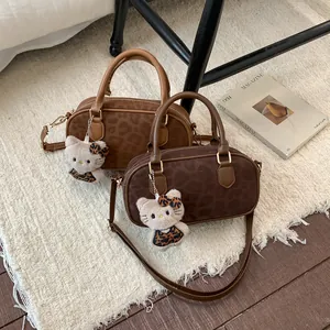 Detailed view of leopard print suede Boston bag with adjustable strap and plush charm