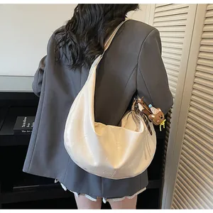 Model view of cream crescent hobo bag with teddy charm and silk scarf detail