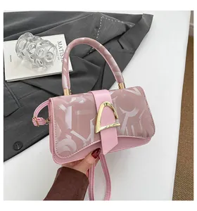 Vue détaillée du sac à main rose avec boucle fer à cheval dorée et motifs abstraits