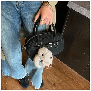 Detail of black vintage square bag with silver buckle and cute plush rabbit charm