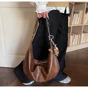 Detailed macro view of soft brown leather hobo bag texture with star and bear charms