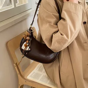 Détail du sac croissant marron foncé avec découpe cœur et accessoire léopard