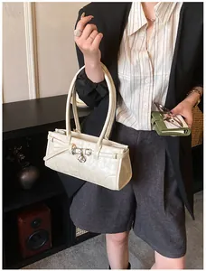Close-up of cream leather shoulder bag with buckle strap details in a lifestyle setting