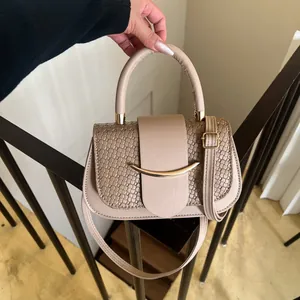Detail of beige tote bag showing smooth flap design with elegant woven texture on sides