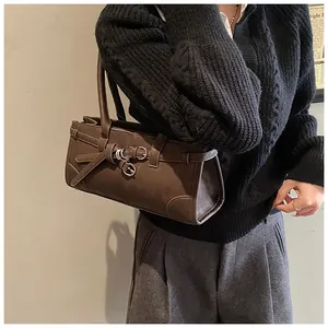 Detail of a dark brown vintage handbag with decorative buckle strap and matte finish