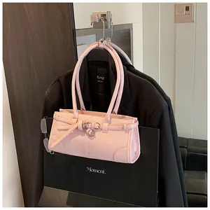Detailed view of a pink rectangular handbag featuring decorative belt buckle and slim straps
