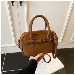 Detailed close-up of brown lychee texture faux leather bag with silver hardware hooks