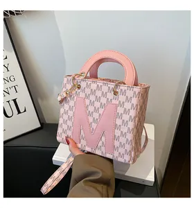 Detailed macro view of pink leather handbag with M letter monogram and gold hardware