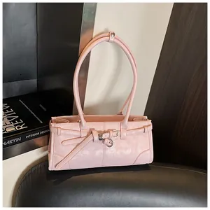 Detail of light pink leather bag featuring belt decoration and sleek metal buckle strap