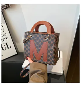 Detail of vintage brown monogram handbag with leather M patch and gold hardware