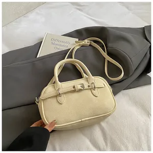 Close-up of beige pebble faux leather texture with decorative buckle and dual handles