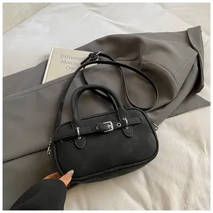 Detailed macro view of black matte Boston bag with vintage buckle and elegant top handles