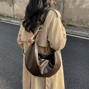 Classic dark brown leather crescent shoulder bag with cute bear charm and silver hardware