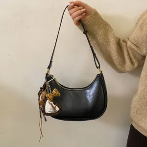 Détail du sac hobo noir en croissant avec miroir cœur léopard et breloques de mode