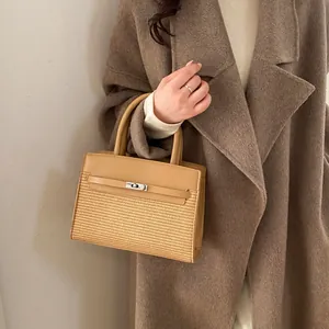 Detail of silver metal twist lock and camel leather patchwork on women's handbag