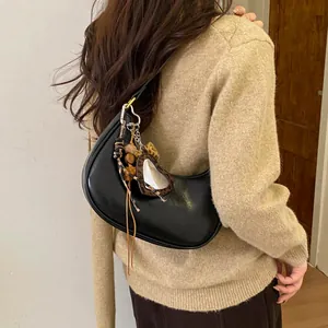Détail du sac croissant noir avec breloques coeur et rubans à motif léopard