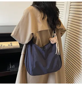 Navy blue canvas tote bag with plush bear charm and striped ribbon for daily style
