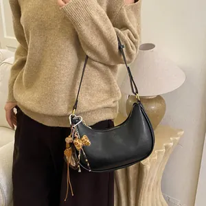 Détail du sac hobo croissant noir avec breloque léopard et boucle en forme de cœur