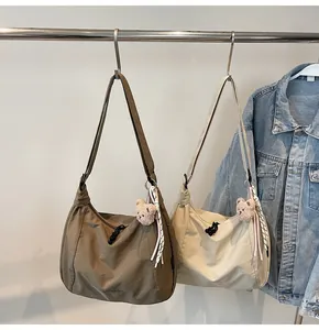 Detail view of large canvas shoulder bags with drawstring design and cute teddy bear pendants