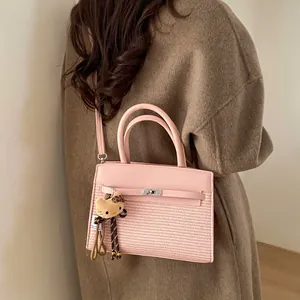 Detailed back view of a pink patchwork crossbody bag worn over a brown wool coat