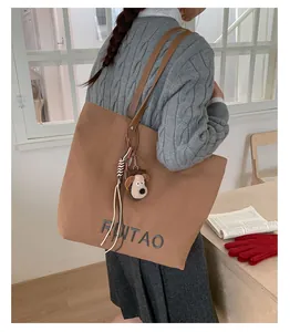 Sac cabas en daim marron avec broderie de lettres et breloque chiot dans un cadre cosy