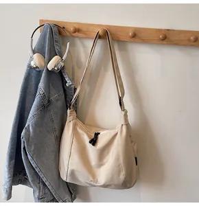Detailed view of beige canvas tote bag with Midola embroidery and black drawstring zipper