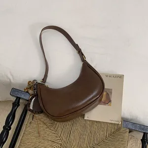 Détail du sac demi-lune marron avec breloque miroir en forme de cœur léopard