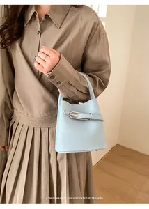 Detail of light blue bucket bag featuring litchi leather texture and silver buckle