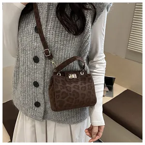 Détail d'un sac seau léopard avec boucles dorées et texture en daim de qualité