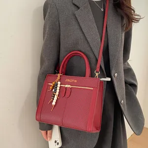 Détail du sac rouge avec texture à chevrons et perles en bois colorées