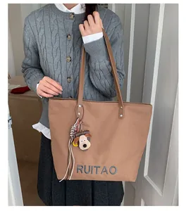 Détail du cabas marron avec lettrage RUITAO et un joli pendentif en peluche chien