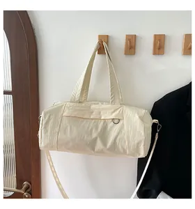 Detailansicht der cremefarbenen Nylon-Kissentasche mit Schultergurt und Metallhaken