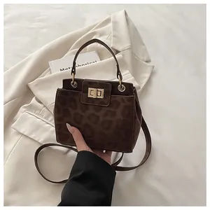 Détail du petit sac seau à imprimé léopard avec fermoir doré et texture en suédine