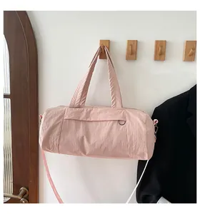 Detaillierte Makroansicht der rosa Nylon-Zylindertasche an einem Holzhaken im Zimmer