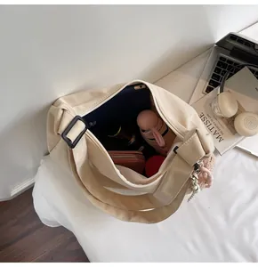 Spacious interior of beige canvas tote bag with zipper and items showing large capacity