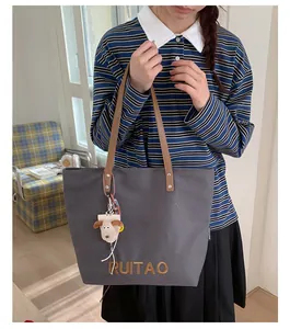 Détail du sac cabas gris foncé avec broderie orange et charme d'agneau mignon