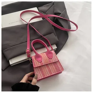 Close-up of pink tweed woven crossbody bag with gold hardware and synthetic leather strap