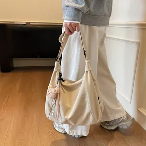 Minimalist off-white canvas tote bag with adjustable strap and pink bear plush charm