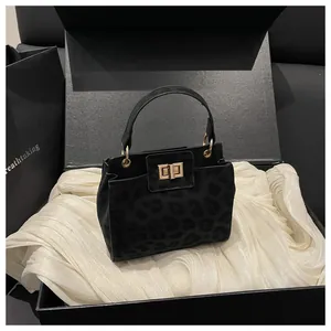 Détail du sac seau noir motif léopard avec fermoir doré et emballage cadeau élégant