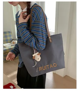 Détails de broderie RUITAO sur cabas en toile gris foncé avec anses en cuir
