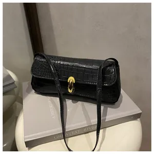 Detailed close-up of a black crocodile pattern shoulder bag with a gold U-shaped metal buckle