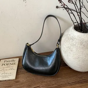 Détail du sac hobo croissant noir avec texture cuir vintage et fermeture éclair dorée