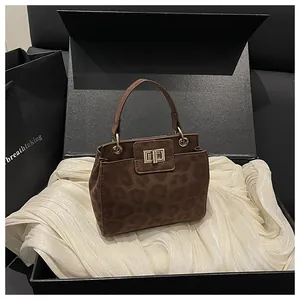 Détail du sac seau à motif léopard avec fermoir pivotant doré sur tissu en soie douce