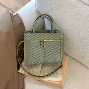 Vue détaillée du sac bandoulière vert avec tissu à chevrons et poche zippée dorée